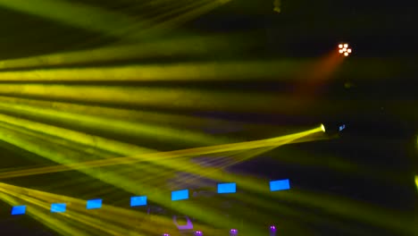 los rayos estroboscópicos amarillos, azules y rojos y las luces de punto crean rayos a través del humo en un evento que se encuentra en una habitación oscura en el interior. los rayos de luz son cinematográficos y hermosos para ver a través del hume.