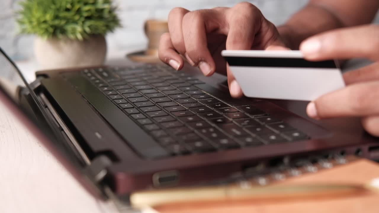 Persona che usa un laptop e una carta di credito per acquisti online
