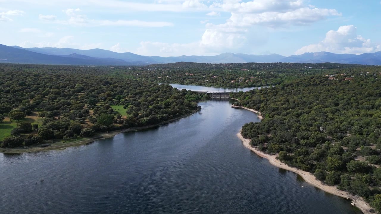 Un fiume che serpeggia attraverso foreste lussureggianti e colline con un ponte in lontananza. Perfetto per documentari sulla natura e contenuti di viaggio.