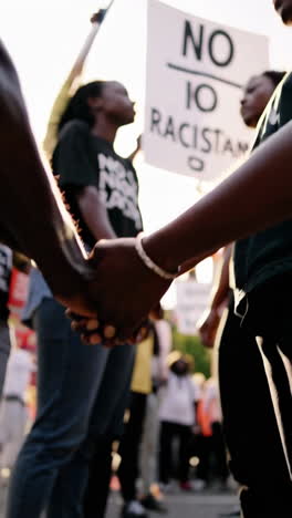 people holding hands in a protest for unity against racism