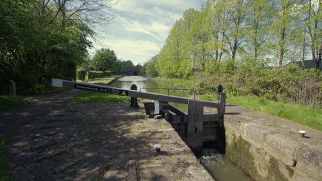 fotografía amplia de una esclusa estrecha del canal en la esclusa de estiramiento en el canal de chesterfield