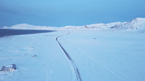 Iceland-white-landscape-at-winter-with-aerial-scenic-view-of-little-road-in-the-middle-of-snow