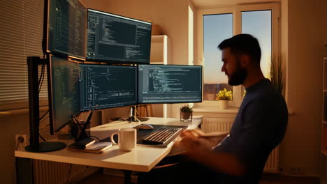 software developer working on multiple monitors in home office