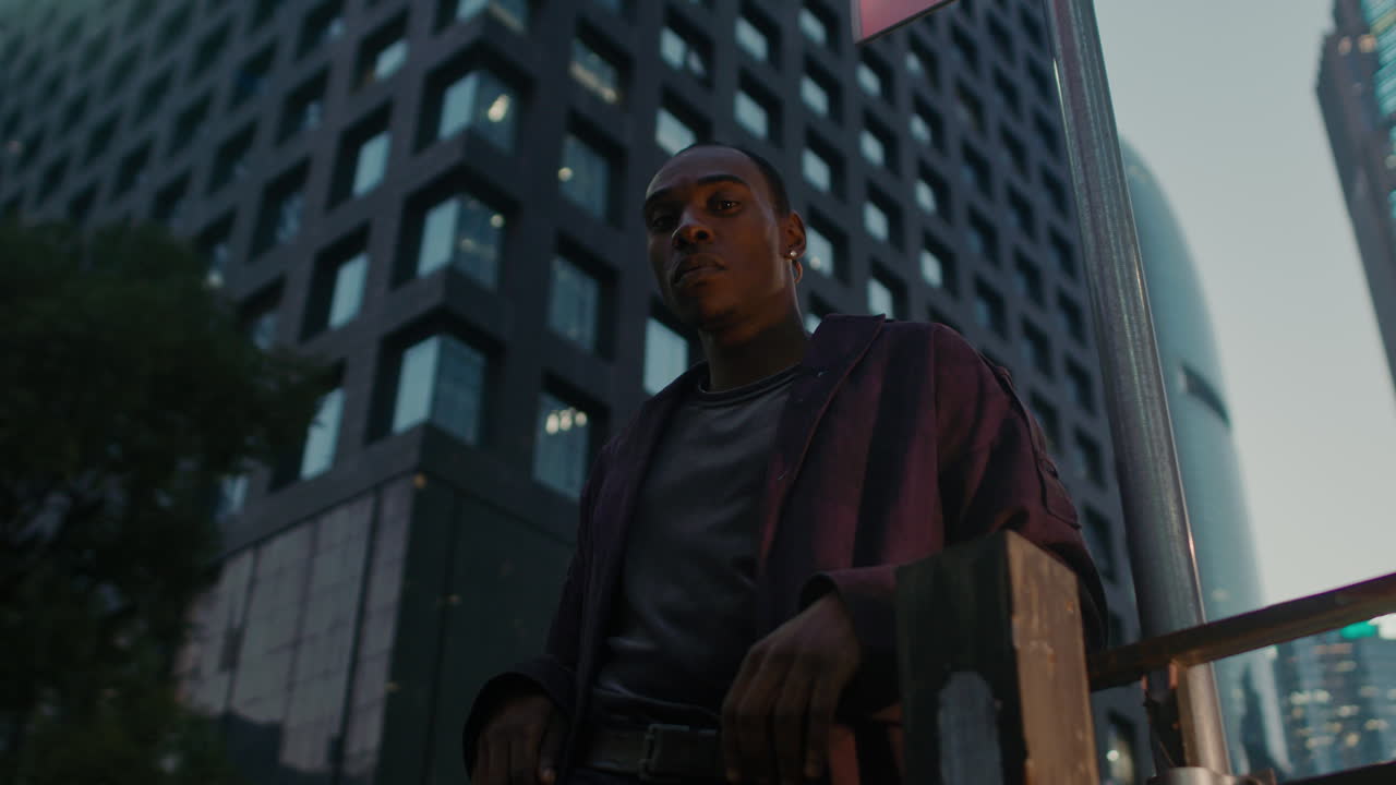 afroamericano negro ángulo bajo bloqueo en la cámara con moderna ciudad inteligente horizonte en el fondo iluminado por la noche