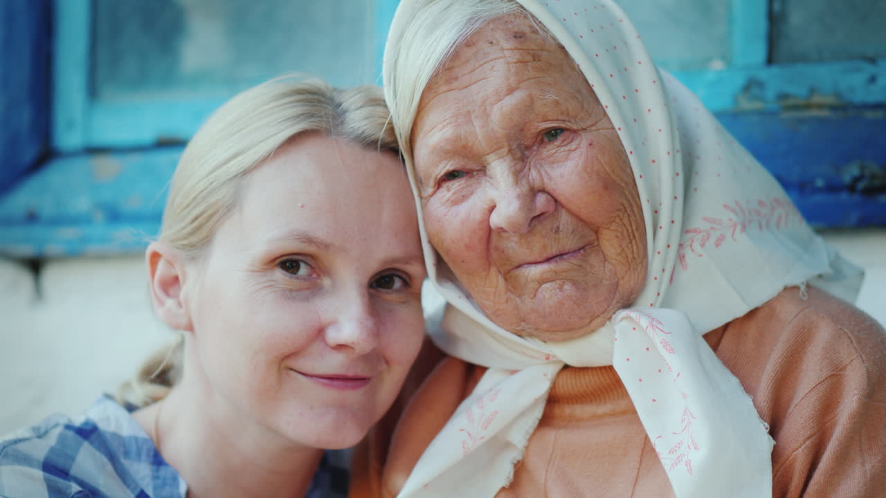 그녀의 손녀와 노인 여성의 초상화 그들은 몇 세대 카메라를보고 포용