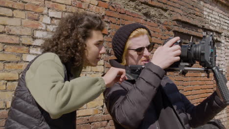 close up view of two production co workers talking and setting up a camera in the street 1