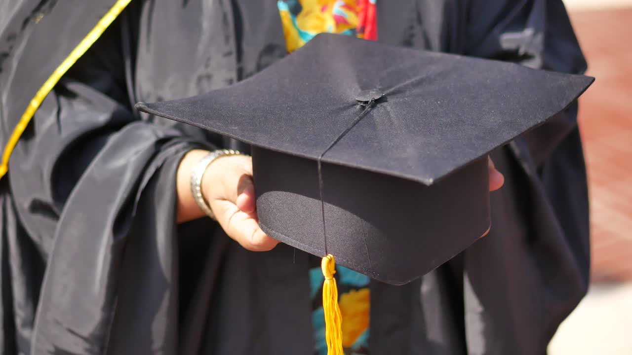 gorra de graduación en la mano
