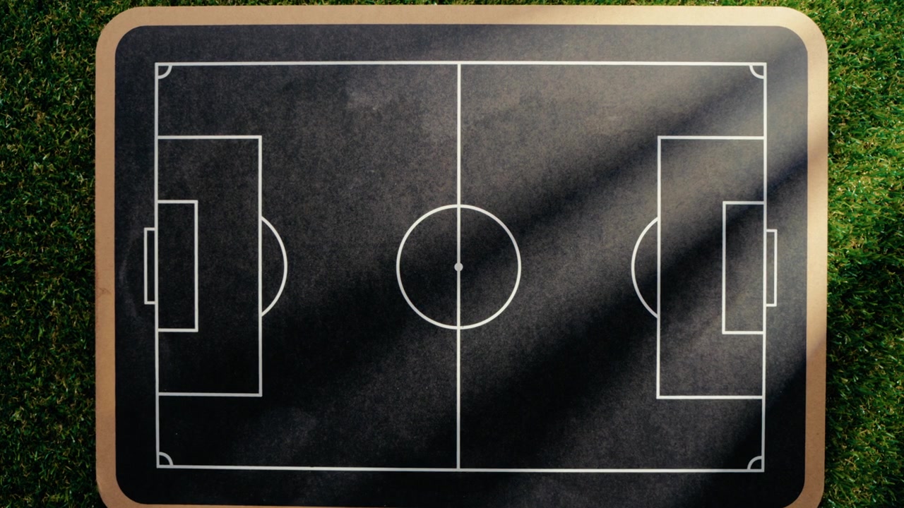 Blackboard with empty football field on grass