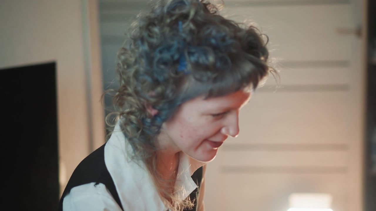 Sessione di studio previsionale illuminata delicatamente, riflessiva. Donna esamina appunti con calma concentrazione, bagliore di lampada ambientale, primo piano di profilo, umore introspettivo, pianificazione di scelte future e dolce rivelazione