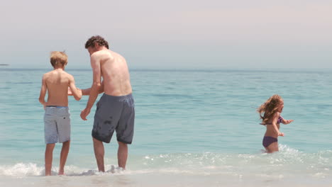 Familia-Caminando-En-El-Agua