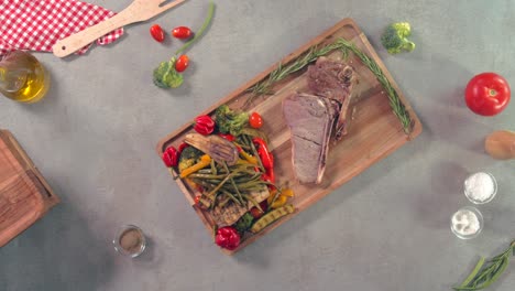 una vista superior de bistec con ensalada de verduras en un plato de madera