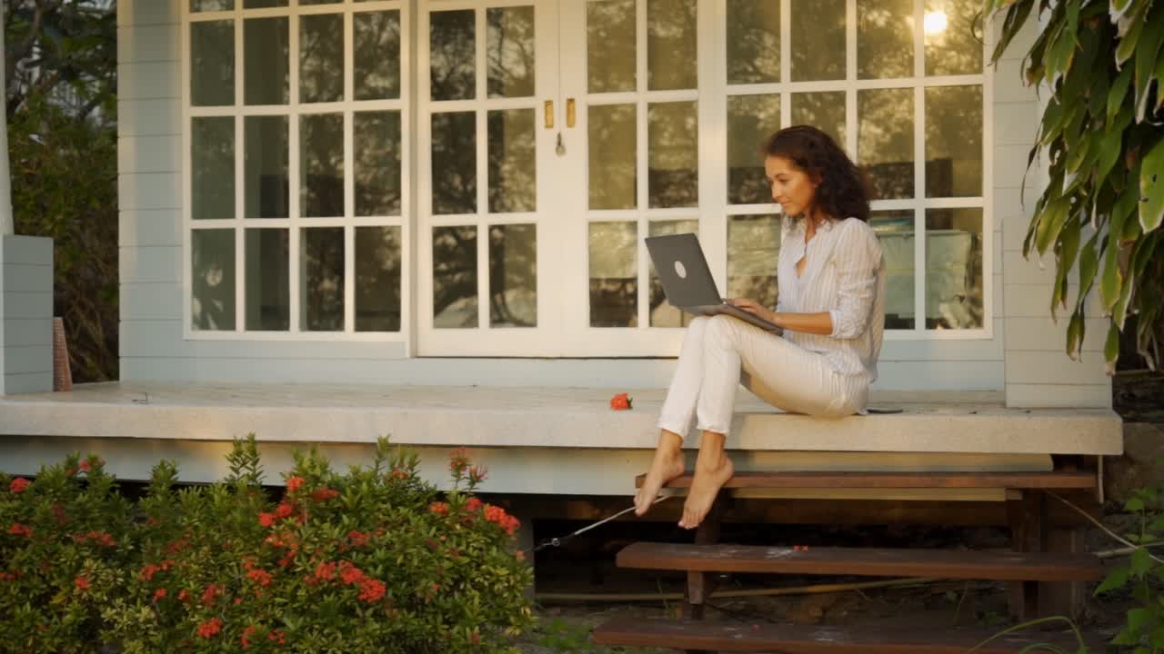 Woman Working on Laptop on a Porch