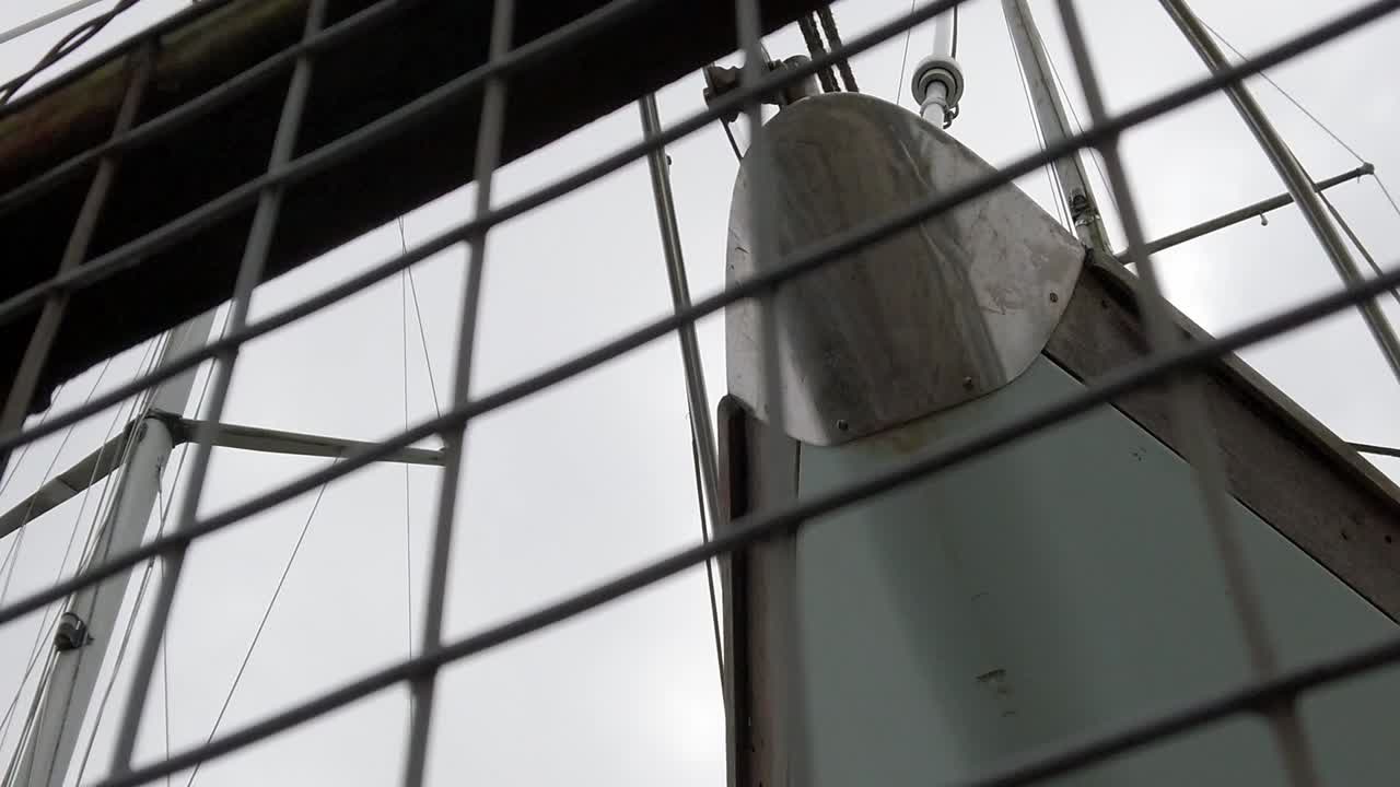 primer plano de la proa del yate de velero celebrada detrás de rejilla metálica segura cerrada astillero vallado lento izquierdo dolly