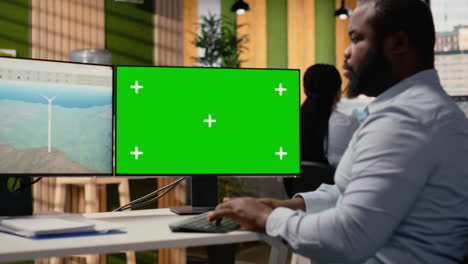 technician works on wind turbine cad design using green screen pc