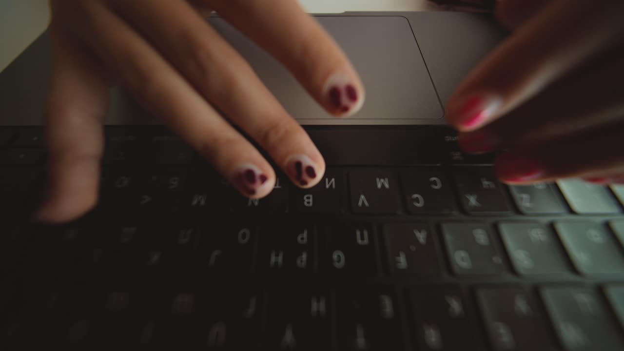 Nærbillede af hænder, der taster og bruger trackpad på bærbar computer