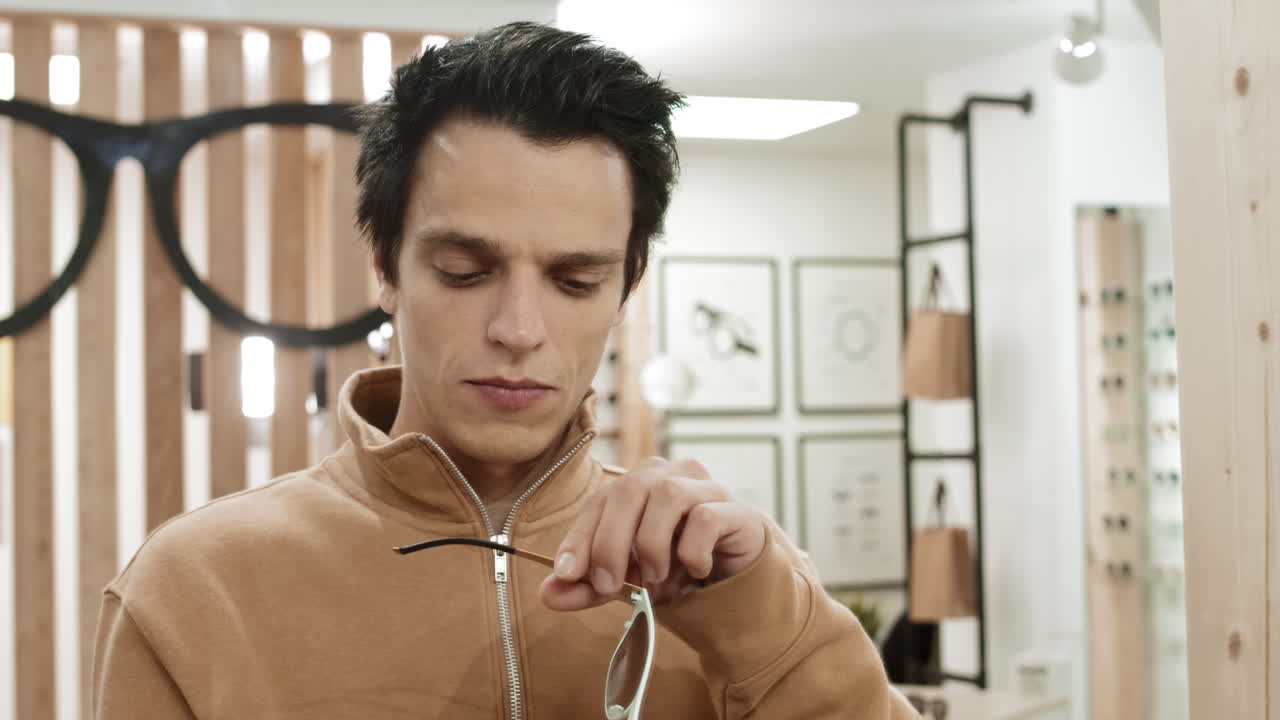 hombre probando gafas de sol en una tienda de ópticos