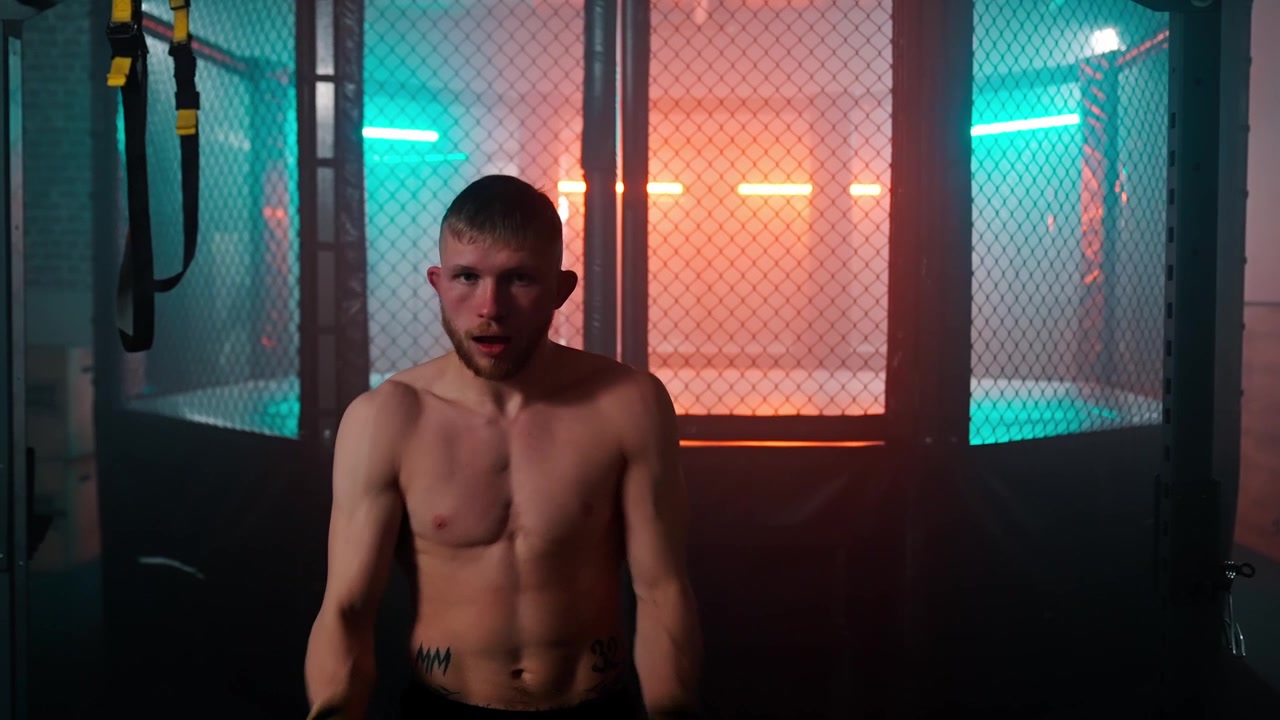 Uomo muscoloso che si riscalda con guantoni da boxe in una palestra illuminata al neon