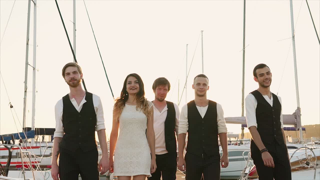 Group of friends walking on a pier at sunset