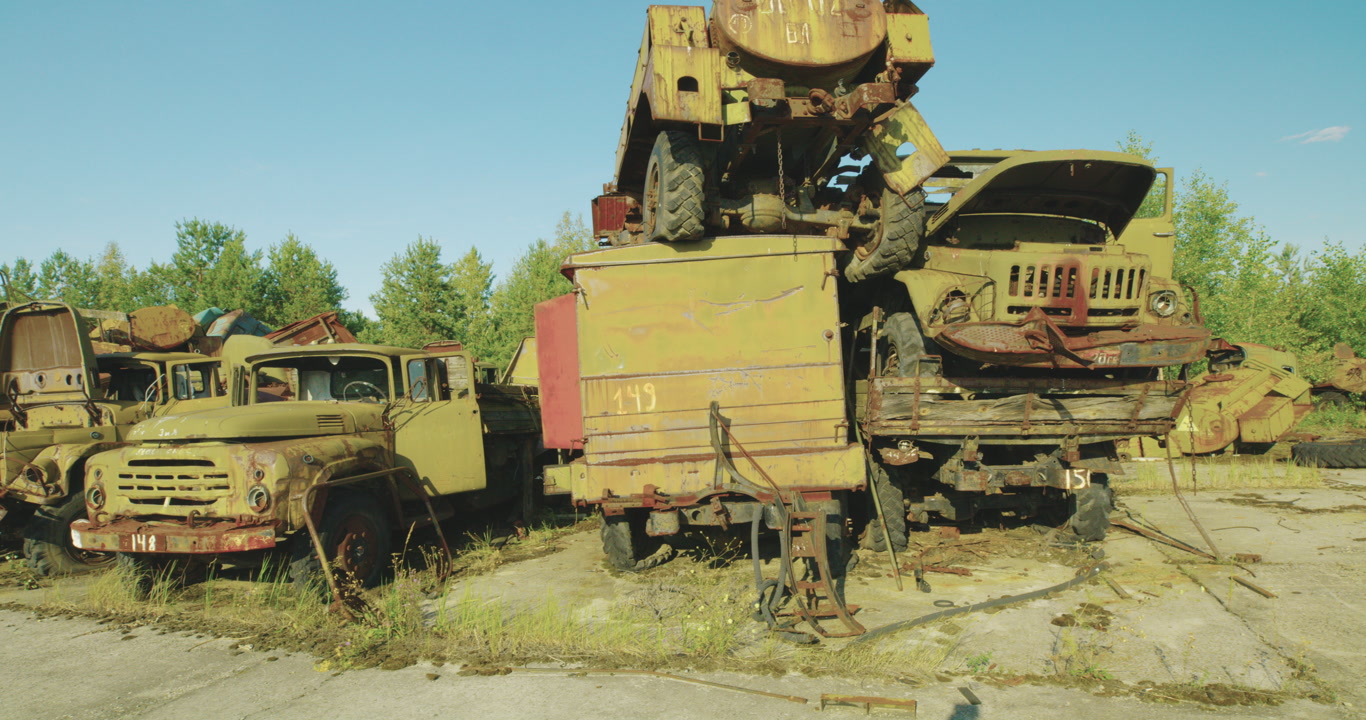 Static shot of radioactive vehicles in the Chernobyl Exclusion Zone's Burikivka Vehicle Graveyard, an off-limits area.