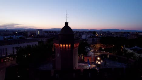 Monumento-De-Castillet-Al-Atardecer-Con-Dj-Mix-En-La-Azotea-Y-Vista-De-Drones-En-Perpignan,-Cataluña