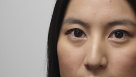 close-up-beautiful-young-asian-woman-face-turns-looking-at-camera-eyes-blinking-isolated-on-white-background