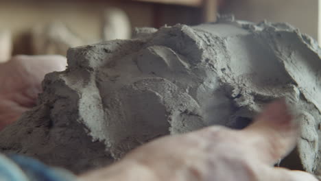 hands of senior sculptor shaping head out of clay