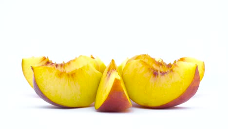 ripe peach fruit slices. rotating on the turntable isolated on the white background. close up. macro.