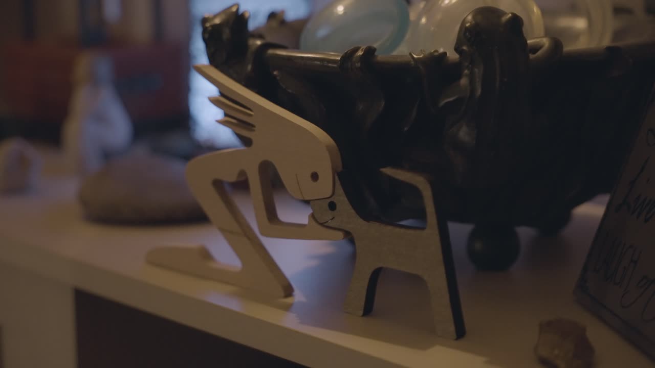 나무로 만든 사람과 애완동물 테이블의 조각이 전시되어 있습니다.