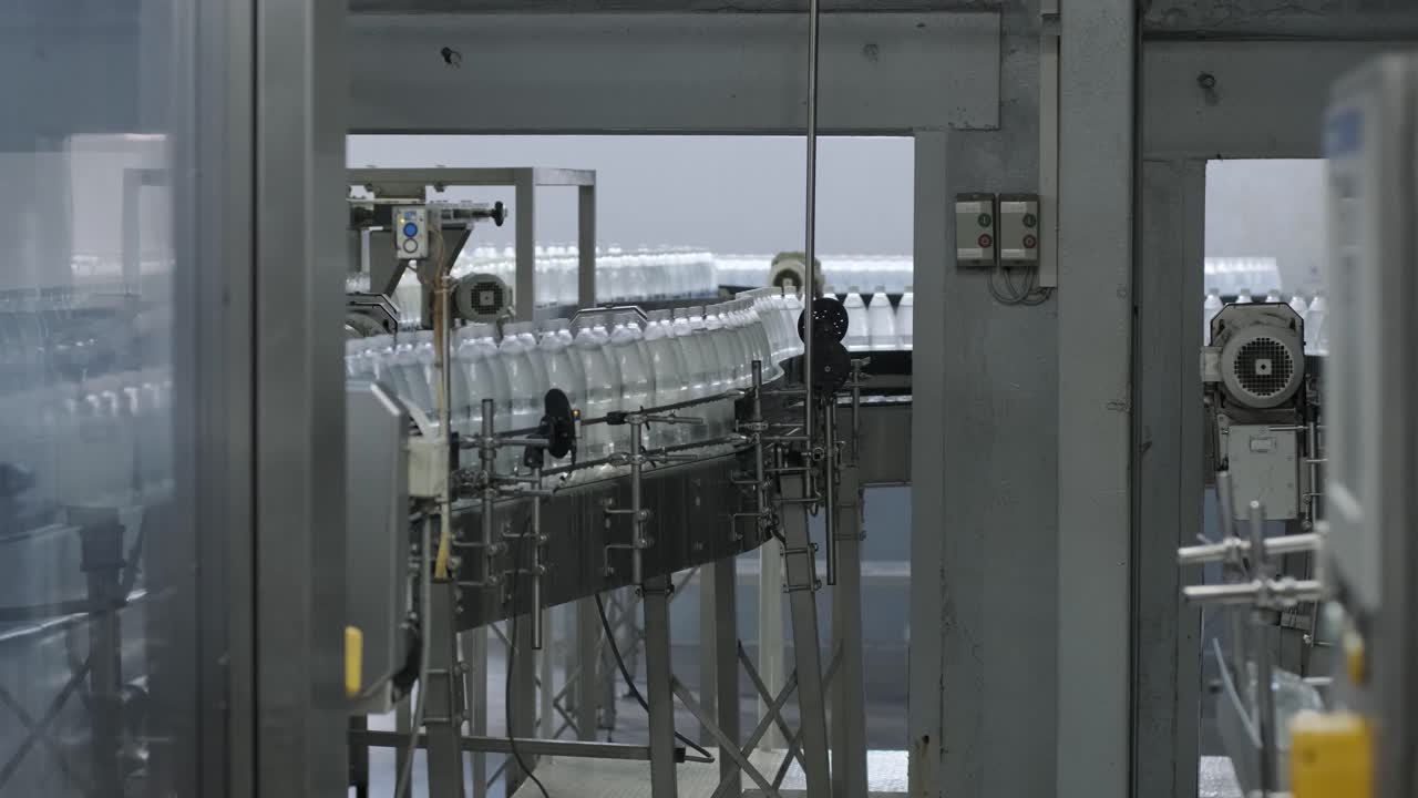 Conveyor belt with bottles of drinking water at a modern beverage plant