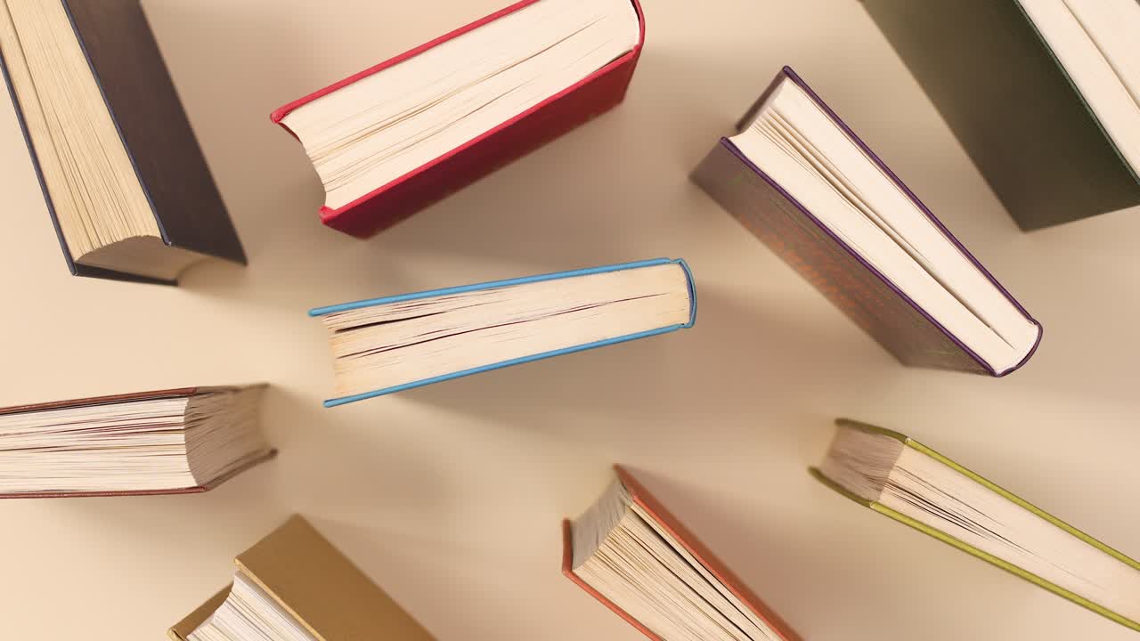 Vintage hardcover books pattern on beige background. Stop motion flat lay