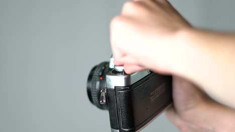 Close-up-of-young-caucasian-hand-winding-film-in-vintage-analog-camera