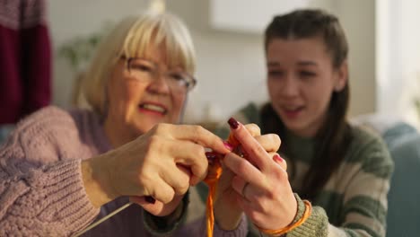 grandmother and granddaughter knitting together