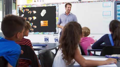 maestro dando una lección delante de una clase de escuela primaria