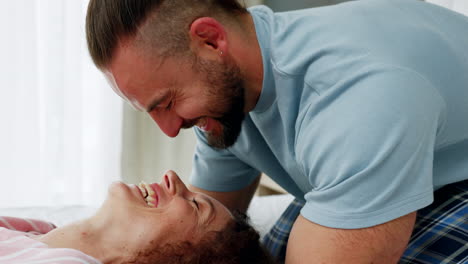 pareja feliz riendo y abrazándose en la cama