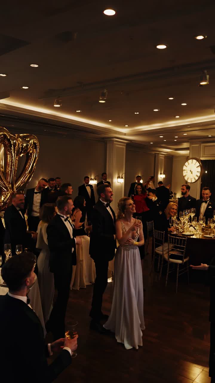 Guests raising their hands and dancing under beautiful fireworks during a wedding reception party, celebrating the newlywed couple in a festive atmosphere