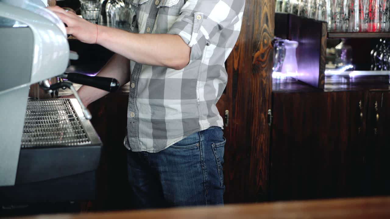 Barista making coffee in the coffee machine.