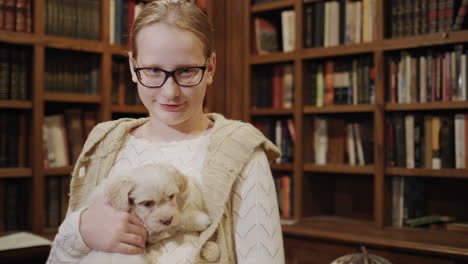 niño feliz en la biblioteca son una niña y un cachorro con gafas. mascotas lindas y la educación