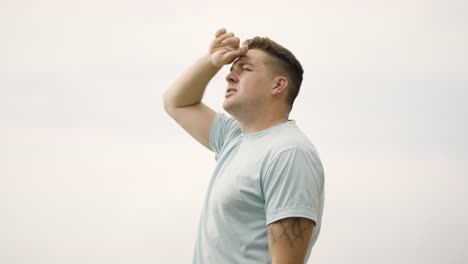 Man-Looking-at-the-Sky-on-Malibu-Beach-Hand-over-eyes-blocking-the-sun