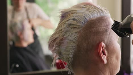 side view woman having her hair cut by a hairdresser