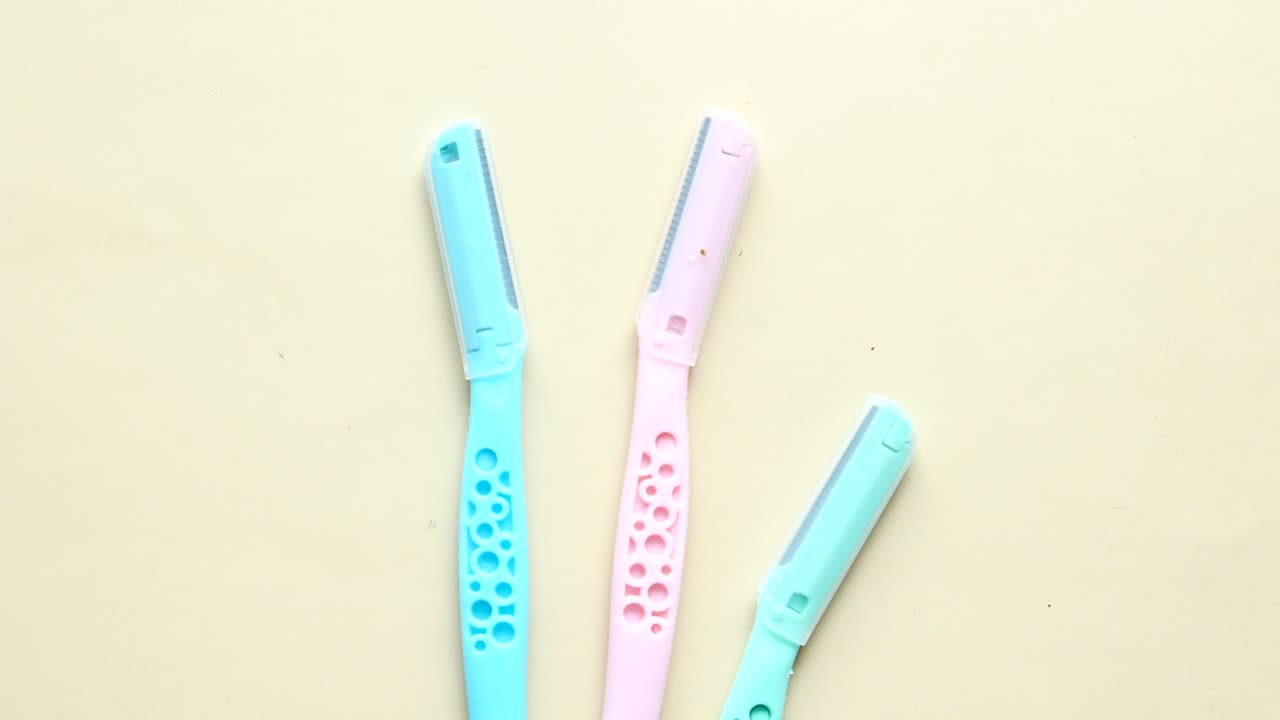 plásticos, afeitadoras y cuchilla de afeitar en la mesa.