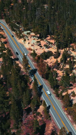 motorway through the rocky landscape on sunny day. roads going by the highway on the mountainous shore of lake tahoe. vertical video