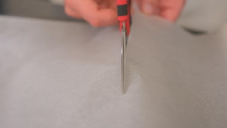 slow motion cutting baking paper towards the camera