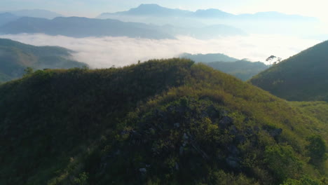 dolly in establishing aerial shot of mountain range with sea of clouds