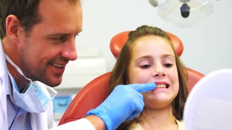 Dentista-Mostrando-Los-Dientes-De-Las-Niñas-En-El-Espejo