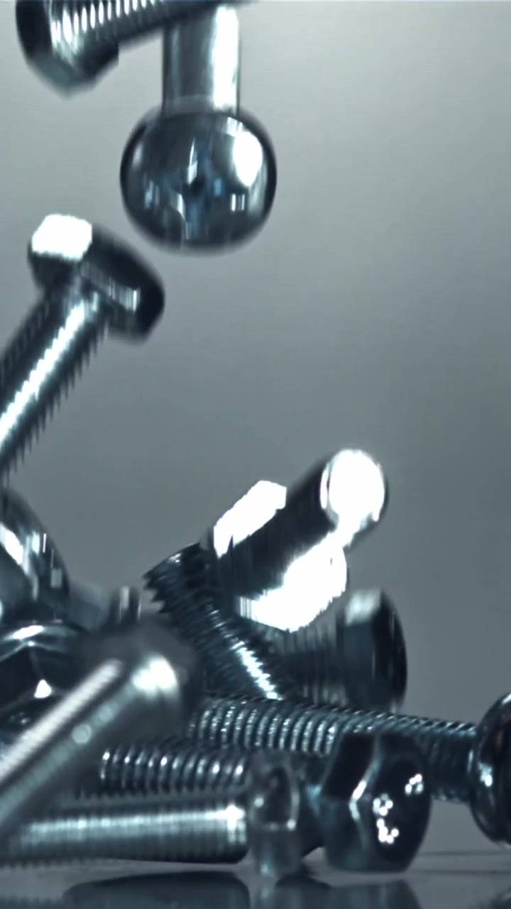 Close-up of Metal Nuts and Bolts Dropping in Slow Motion