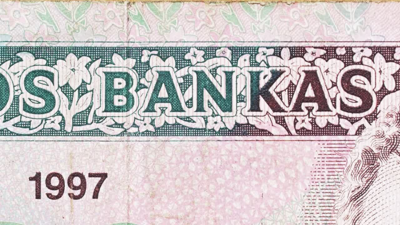 Macro pan revealing “Lietuvos Bankas” on a Lithuanian banknote