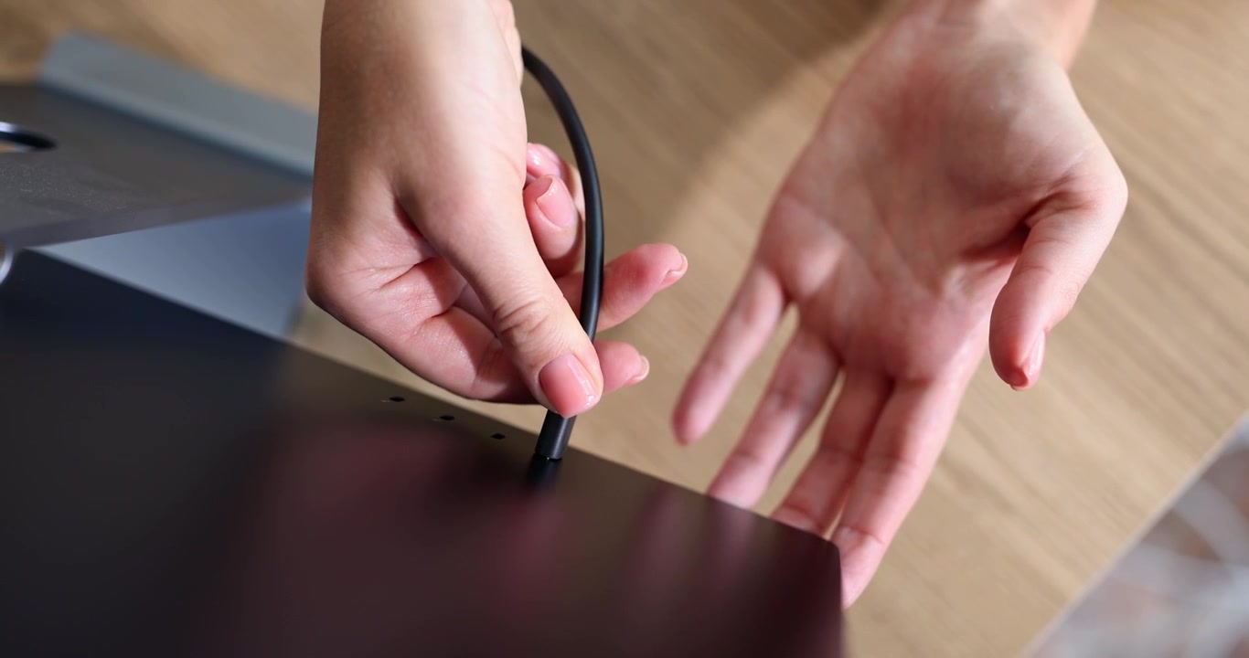Hands insert a plug into a black screen a closeup