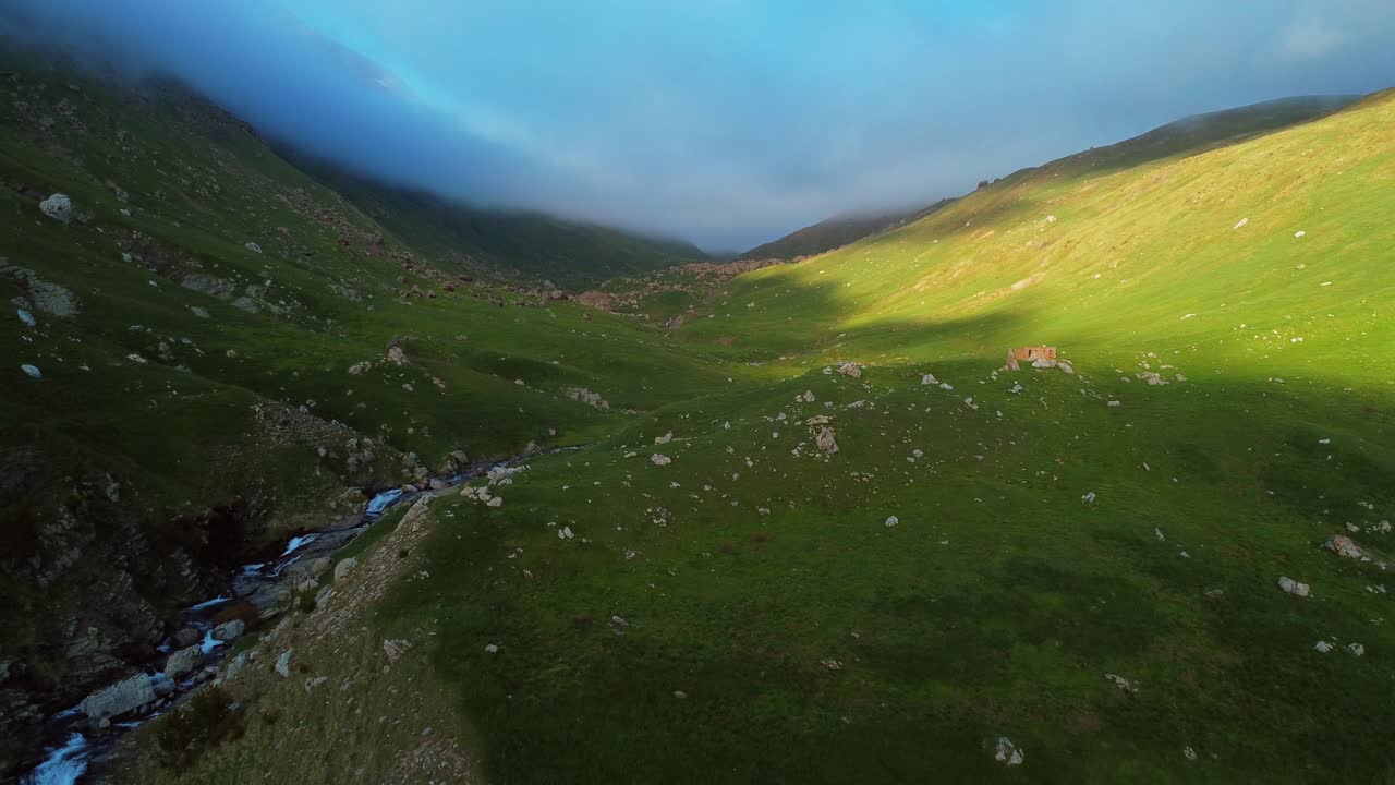 vista aérea de un valle nublado en las montañas durante la puesta de sol en primavera