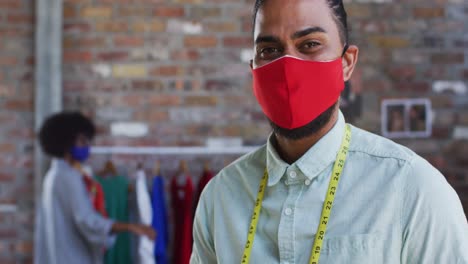 feliz diseñador de moda masculino de raza mixta mirando a la cámara y sonriendo