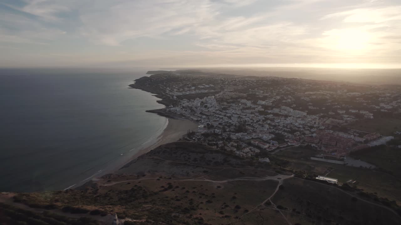 Distant sunset view of Praia da Luz beach and town by Atlantic Ocean, Algarve